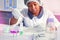 African scientist, technical assistant or medical technician in white coat, protective hat and gloves optimizes PCR testing for