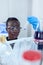 African scientist working with blue liquid in chemical test tubes