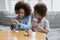 African siblings using playdough have fun making diverse shapes