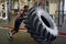 African Sportsman Flipping Tire in Gym