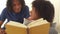 African teen couple reading a book