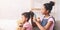 African teen girl combing younger sisters hair