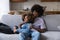 African teenager couple relaxing on sofa smiling staring into distance