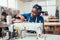 African textile worker sewing on production line. Dressmaker woman working with sewing machine