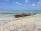 African traditional old boat at ocean shore under the blue sky.