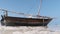 African Traditional Wooden Boat Stranded in Sand on Beach at Low Tide, Zanzibar