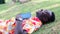 African traveler man lying sleep on the grass with opened book