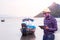 African trawler captain stands in front of the ship using a tablet to search for weather and maritime information.Marine business