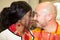 African Wedding Bride in traditional outfit with caucasian groom kiss
