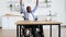 African wheelchair user celebrating success by raising hands up
