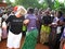 African and white woman relief worker dancing for joy in front of villagers Uganda Africa