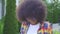 African woman with an afro hairstyle photographer with a camera on the urban landscape looking at the camera and smiling