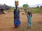 African woman & child villagers doing daily work & chores village life