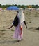 African woman Combs hair with colorful braids on the beach in su