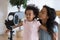 African woman and daughter turn their faces to blowing fan