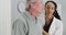 African woman doctor listening to elderly patient breathing