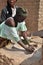 African woman grain mill with stones