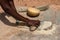 An african woman grinding cereals millet