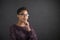 African woman with hand on chin thinking on blackboard background