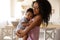 African- woman with her baby in kitchen. Happiness of motherhood