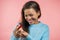 African woman holding small jewelry box with proposal diamond ring on pink wall background. Lady smiling, she is happy