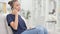 African Woman with Laptop Talking on Smartphone at Home