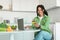 African woman ordering groceries with credit card and laptop indoor