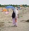 African woman Peddler Combs hair with colorful braids on the bea