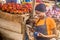 african woman selling in a local african market holding a mobile point of sale system and using her mobile phone