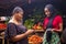 African woman shopping food stuff in a local market paying by doing mobile transfer via phone for a trader