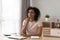 African woman sitting at desk holding smartphone talk voice message