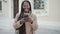 African woman smiling using smartphone at street