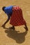 An African woman spreads rice to dry.