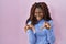 African woman standing over pink background smiling funny doing claw gesture as cat, aggressive and sexy expression