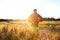 African woman in traditional clothes standing in field at sunset