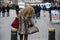 african woman wearing printed leopard winter fur coat and guess hand bag standing in the street