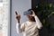 African woman wearing VR helmet touching air with finger, testing modern hi-tech future gadget