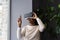 African woman wearing VR helmet touching air with finger, testing modern hi-tech future gadget