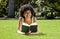 African women lying on the grass reading a book