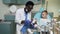 African young dentist teaching little boy how to brush teeth on the plastic model.