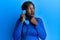 African young woman speaking on vintage telephone serious face thinking about question with hand on chin, thoughtful about