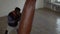 Afro american boxer punching the heavy bag in the gym, high angle view