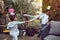 Afro-American boy and girl playing in the backyard with plastic swords