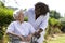 Afro-american caregiver talking to a disabled senior woman