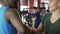 Afro-american and caucasian men shaking hands in gym, international friendship