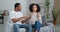Afro american couple newlyweds boyfriend and girlfriend sitting at home couch quarreling swear jealous husband screaming