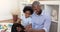 Afro American dad play videogames on pad with little son