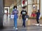 Afro american ethnicity female teens strolling downtown for shopping wearing protective mask