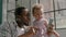 Afro-American father plays on smartphone with toddler girl
