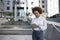 Afro american girl is standing on the street near the office building. It works on a tablet